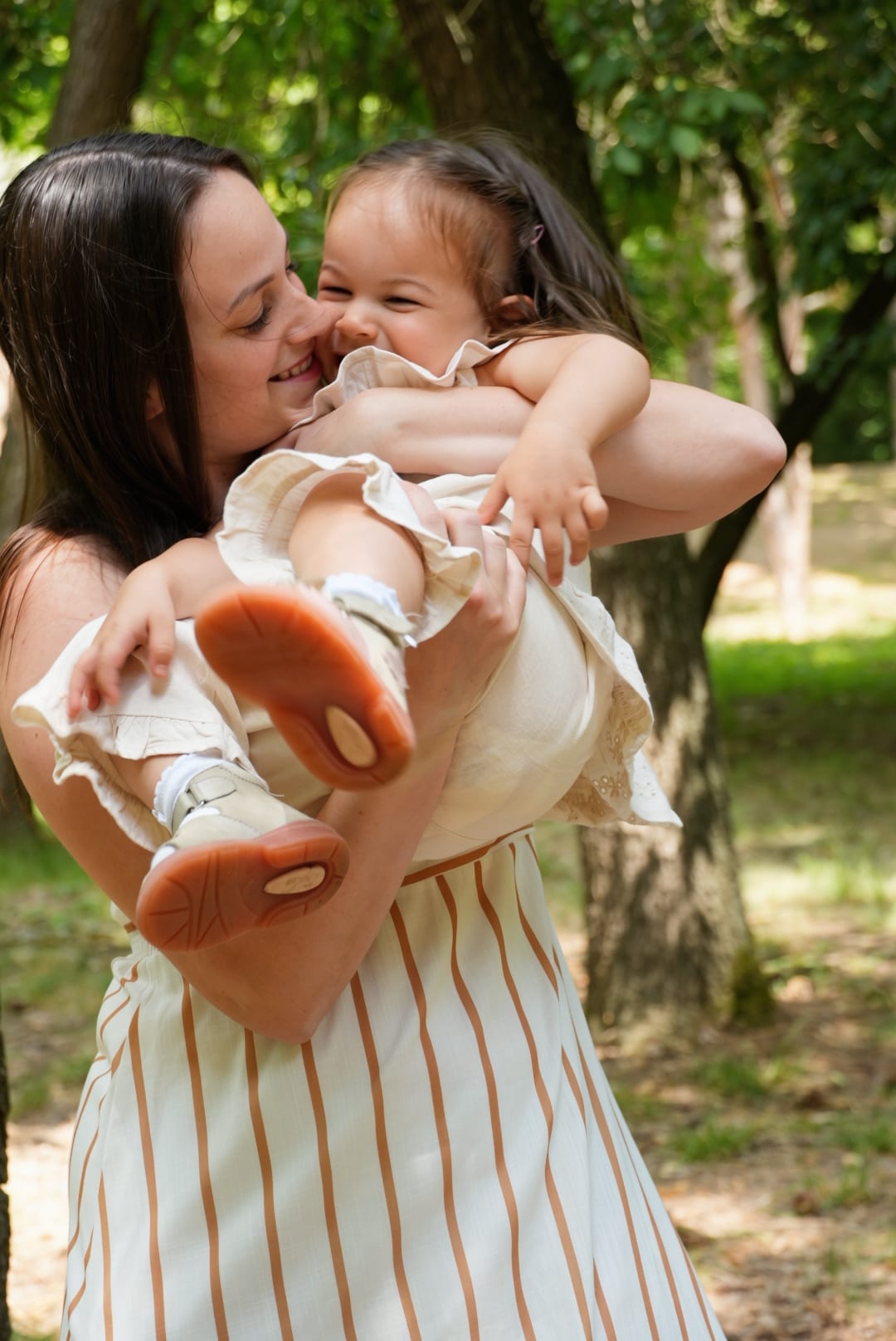 Mama hält ihre lachende Tochter im Arm